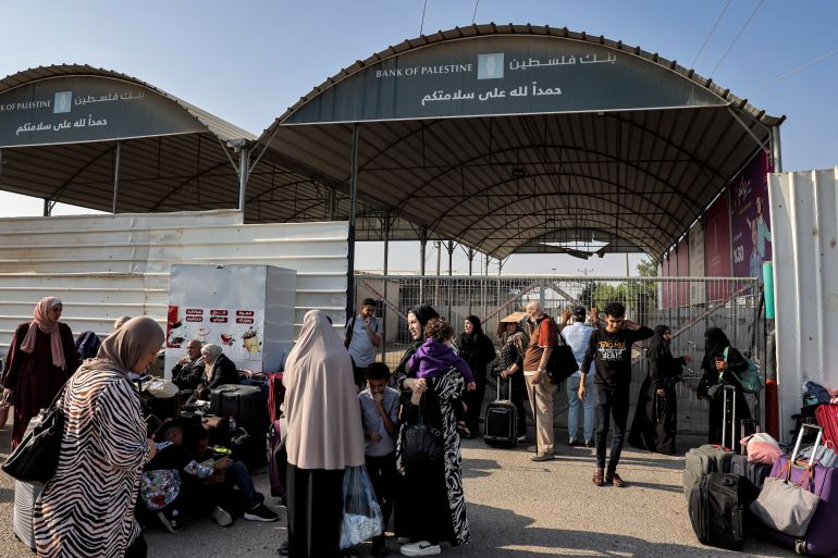 People wait at the Rafah border crossing with Egypt in the southern Gaza Strip on November 1, 2023