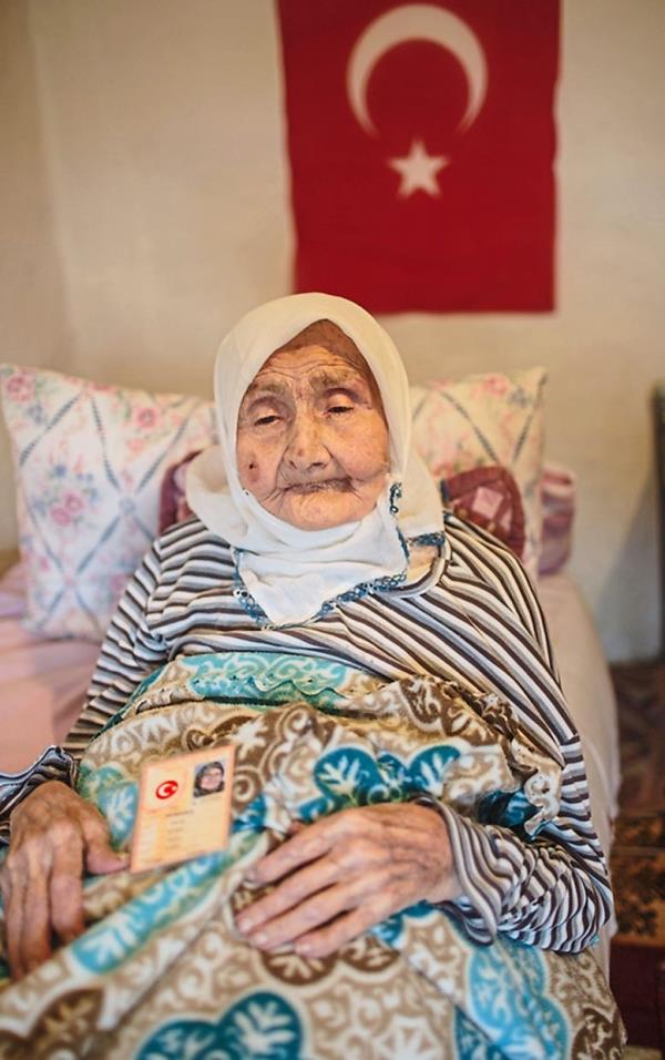 Kiymet Akyuz, 101, in her house in the village of Yenice with her Turkish identity card on her lap. Akyuz’s family was among those who arrived in Yenice from Thessalo<em></em>niki as part of a population exchange between Greece and Turkiye in 1923.