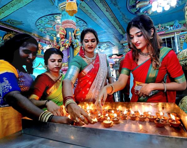 Lighting up: Theepa Mogan, 23, (right) with her mother and others lighting diyas during the special Deepavali prayer at Arulmigu Karumariamman Temple in Seberang Jaya, Penang. — ZHAFARAN NASIB/The Star