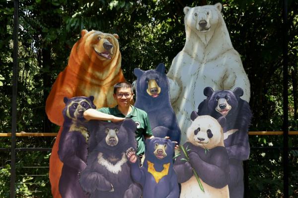 Wong with life-sized cutouts of various bear species around the world at the Bornean Sun Bear Conservation Centre.