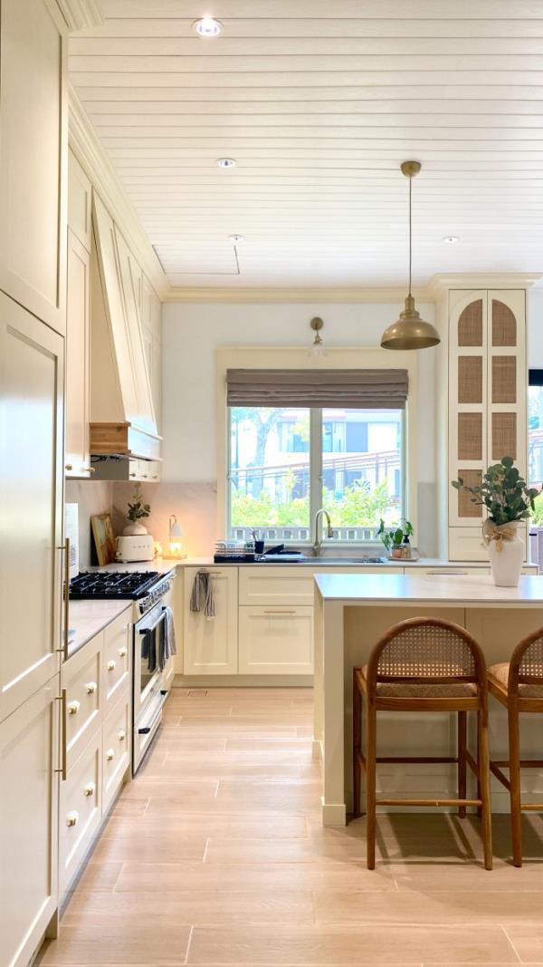 The kitchen features a classic and timeless design with built-in appliances and white cream cabinets. 