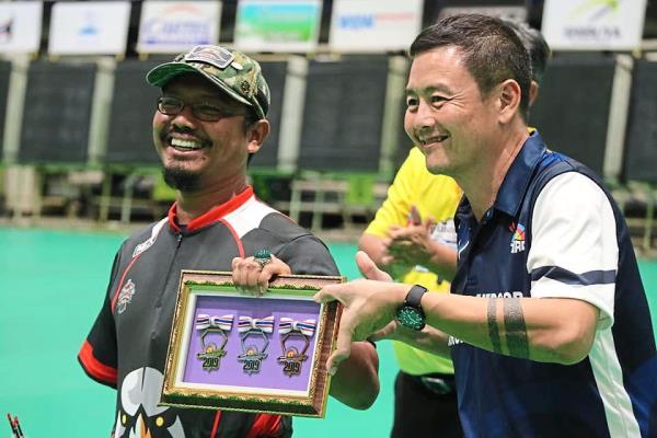 Khairol getting a special achievement award from the organisers of the 2019 Thailand Princess Cup Indoor Archery tournament.