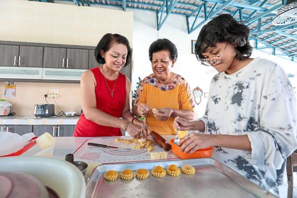 Hendroff (centre) has roped in her daughter Lydia (left) and granddaughter Gabrielle to prepare pineapple tarts for the festive season. 