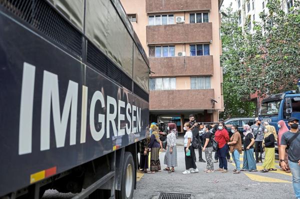 Some foreigners being taken for processing at the Immigration Department. — CHAN TAK KONG/The Star/Bernama