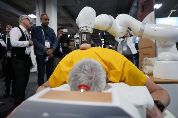 An attendee receives a massage from the iYU AI-assisted massage robot, by Capsix Robotics during the CES tech show in Las Vegas. — AP