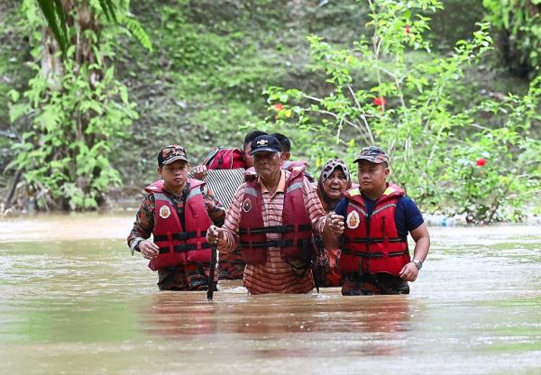 While rescue perso<em></em>nnel help senior citizens Dockery Raymond, 75, and his wife Rahilah, 68, evacuate to a relief centre from their home in Kampung Rancangan Cocos. — Bernama