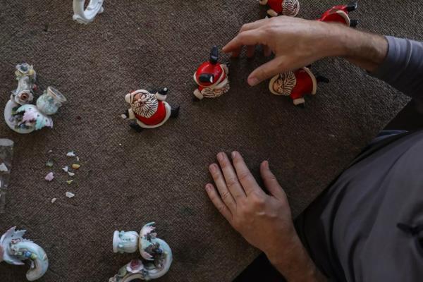 Laborde works on repairing Santa Claus figurines from a client who salvaged them from her mother's estate.