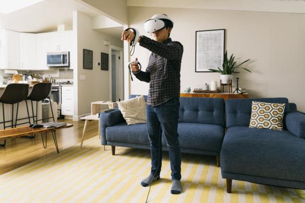Brian X. Chen wears Sony’s Playstation VR in Oakland, California. Although the headset dominated the high-powered VR space for years, a Sony executive recently called VR a ‘challenging category’ because VR had not changed much for the games industry. — Jason Henry/The New York Times