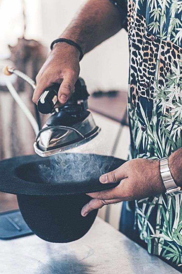 Using a steam iron to crown shape a hat helps soften the hat body material, making it pliable and easier to mold into the desired shape.