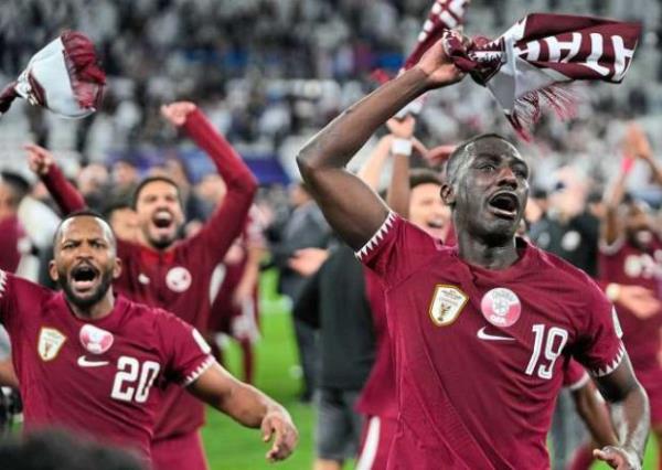 Qatar’s Almoez Ali (right) celebrates with teammates after winning the match against Iran. — AP
