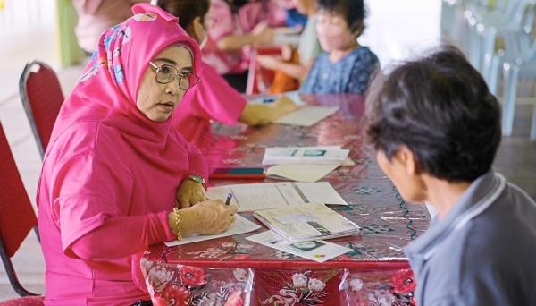In Dalat, Matron Kamariah of SBCSG carrying out clinical breast examination registration. Photo: SCAN