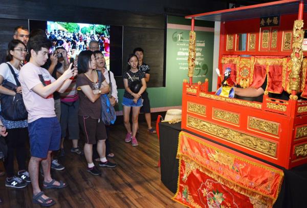 A demonstration of potehi, or glove puppet theatre, catches the attention of visitors during a tour of the Penang House of Music in George Town. Photo: The Star/Jeremy Tan
