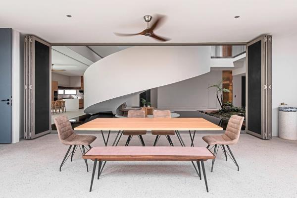 A dining space next to the grand staircase at Helical Pearl House.