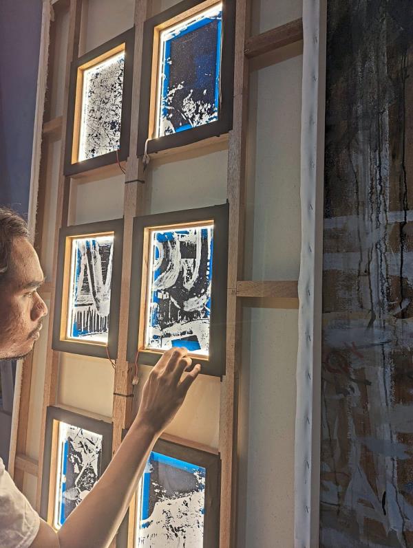 A look behind the canvas as Syahmi fits the LED light to one of his paintings.  Photo: Core Design Gallery
