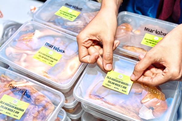 Stickers reminding recipients to consume the food within two hours are affixed to each packet. — MUHAMAD SHAHRIL ROSLI/The Star