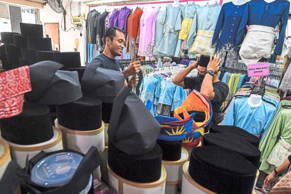 Getting the fit right: Visitors trying on so<em></em>ngkok at KM Plaza in Seremban. — Bernama