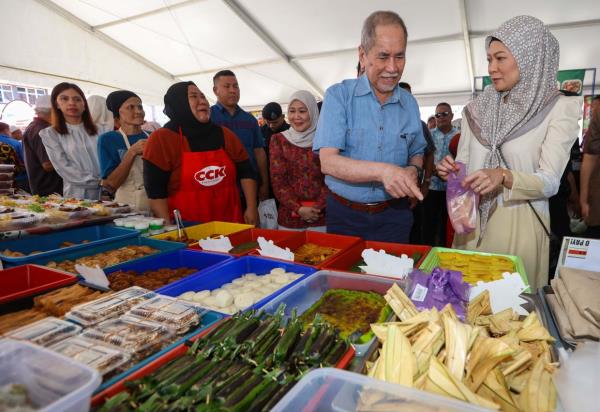 Sarawak Yang di-Pertua Negeri Tun Dr Wan Junaidi Tuanku Jaafar and his wife Toh Puan Fauziah Mohd Sanusi buying local kuih at the Satok Ramadan bazaar. — ZULAZHAR SHEBLEE / The Star