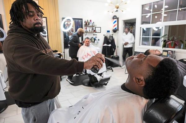 Wayne ‘Paper Kutz’ Threets (left) adding the final touches to Grant High School student Amiere Lewis’ shave.