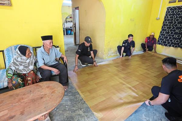 Brand new: Policemen laying the linoleum in Ross’ home in preparation for Hari Raya.      