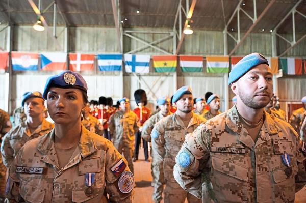 Members of the UN Peacekeeping Force in Cyprus (UNFICYP) take part in a ceremony marking the 60th anniversary of their presence on the eastern Mediterranean island, in the buffer zone separating the divided Cypriot capital Nicosia on March 4, 2024. This year marks a triple anniversary for the Mediterranean island. It's 60 years since the arrival of the blue berets, 50 since an Athens-backed coup aimed at uniting Cyprus with Greece triggered a Turkish invasion that divided the island, and 20 since a referendum saw Greek Cypriots reject a UN reunification plan. (Photo by ETIENNE TORBEY / AFP)