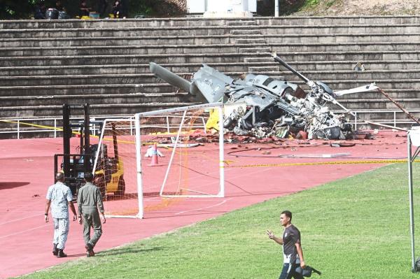 The mangled remains of one of the helicopters that crashed on a field at the Lumut naval ba<em></em>se. — ZULAZHAR SHEBLEE/Ro<em></em>nNIE CHIN/The Star