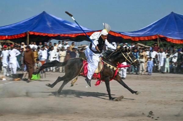 A rider competing in the tent pegging event at the annual mela (carnival) at a Sufi shrine in Shah Jiwana, Jhang district, Punjab, Pakistan. Photo: AFP 