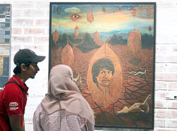 Visitors take a closer look at S. Amin Shahab’s 'Dedaun Masa' painting from 1982, which is an unused album cover artwork. Photo: The Star/Azlina Abdullah 