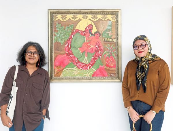 Ika stands beside her work 'Bonda', inspired by a classic song from M. Nasir's album 'Canggung Mendonan'. Her husband Kide, who has two paintings in the show, is seen on the left. Photo: The Star/Azlina Abdullah 