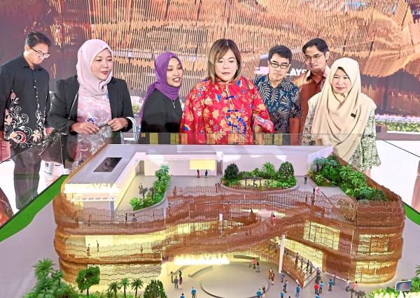 Inspired by songket: Visitors looking at a model of the Malaysia Pavilion at Menara Miti.