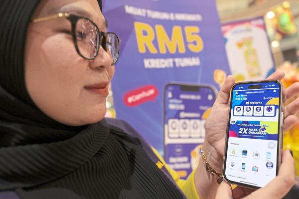 Smooth operator: Mydin staff Shafika Hamson showing the newly launched MydinPay ewallet in Subang Jaya.