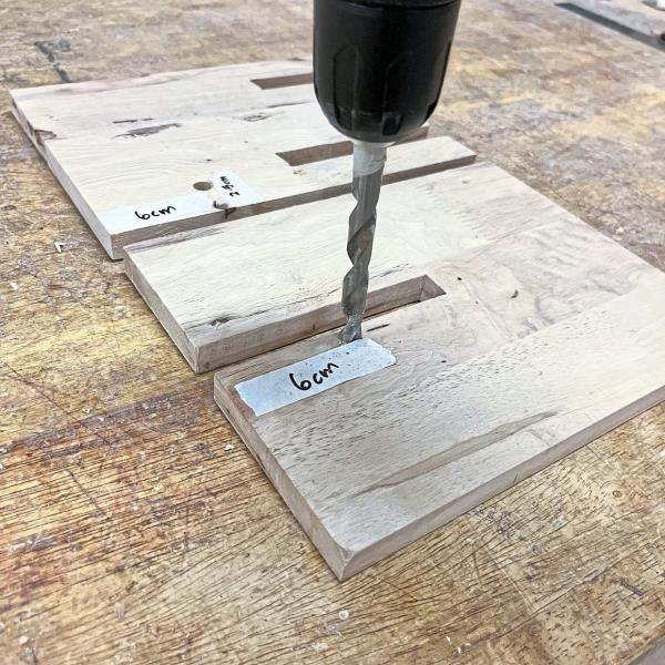 Use a drill driver with a 10mm drill bit (or bigger to fit your phone connector) to drill a hole on each board. These holes will allow the phone wire to go through, ensuring your charging station is as functional as it is stylish.