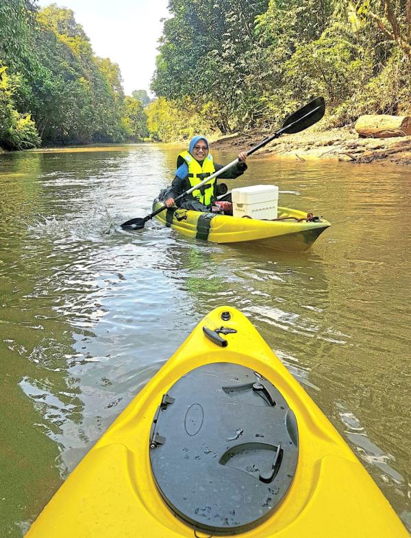 A young kayaker breezing along a pleasant stretch of Sungai Kenong that is free of obstacles. 