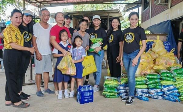 Hyellene Danius (third right) presenting the food basket to recipients while KDCA Women’s Council chairman Joanna Kitingan (left) and other Unduk Ngadau finalists look on.