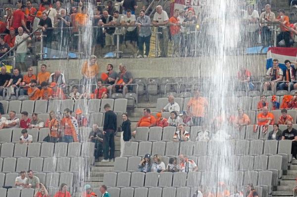 Fresh shower: Water pours from the stadium roof during a heavy rainfall before the semi-final match between Holland and England. — AP