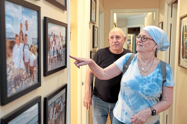Here is Lynn Oxenberg with her husband, Larry, showing off family photos in the hallway of their Elkins Park, Pennsylvania, home.