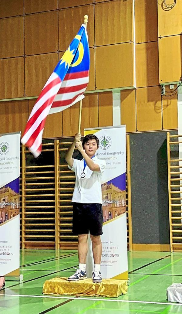 Proud winner: Gan waving the Malaysian flag after winning the gold and the bro<em></em>nze at the IGC in Vienna.