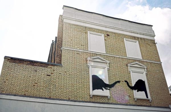 A photograph taken on Aug 6, shows a Banksy artwork, depicting elephants, painted on the side of a building in west London. Photo: AFP 