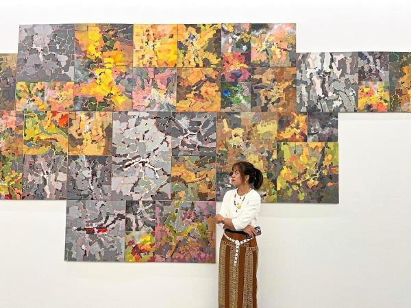 Curator Kyel stands before Than’s 'Mapstracts' series (acrylic on canvas, 2024). Photo: Rizal Johan 