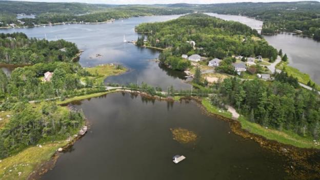 An aerial view of an island dotted with houses and wooded areas.