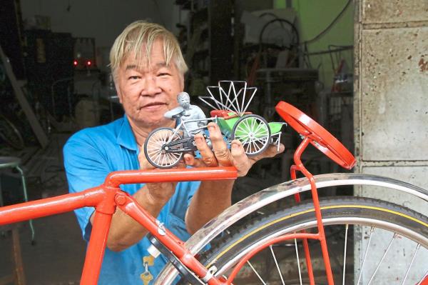 Fourth-generation trishaw-maker Choo Yew Choon showing the mini figurine of himself, made by Low, for the ‘Declining Artisans’ sculpture trail at George Town Festival 2024. Photo: K.T. GOH/The Star