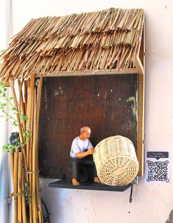 A mini figurine of rattan weaver Sim Buck Teik, put up at the Seang Hin Leong shop on Beach Street as part of the ‘Declining Artisans’ sculpture trail. Photo: K.T. GOH/The Star