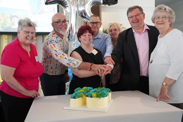 Carinity service users and CEO Kevin Griffith cut a 75 year birthday cake
