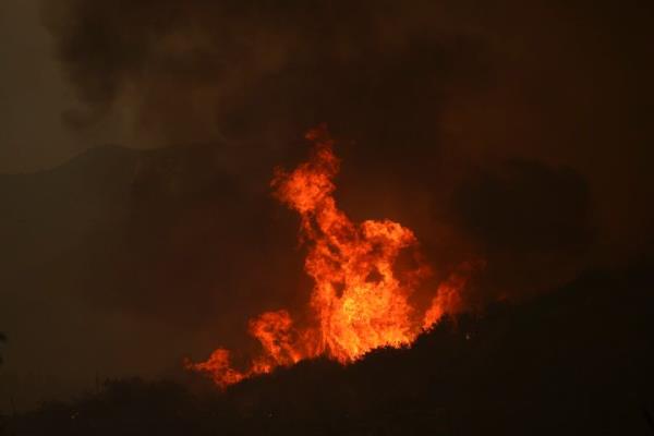 Flames from the Line Fire rise over a hilltop on Sept. 7, 2024, near Running Springs, Calif.
