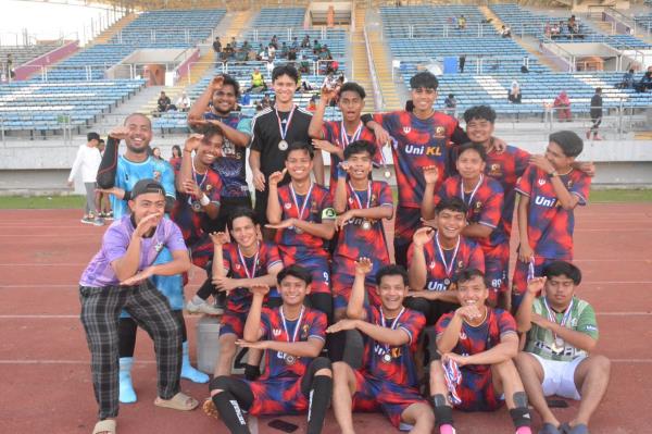 The football team from University of Kuala Lumpur (UniKL) 'strike' a pose with their medals.