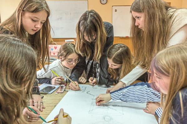 The girls of Kovaliova’s Class 6H working together on sketches depicting their wartime experiences in their classroom in Kyiv, Ukraine. — ?2024 The New York Times Company