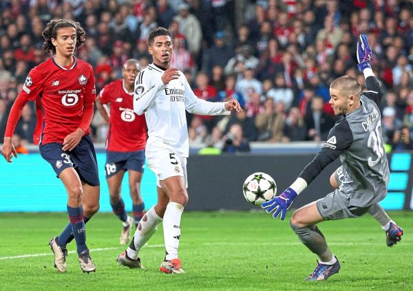 Lille goalkeeper Lucas Che<em></em>valier saves a shot by Real Madrid’s Jude Bellingham. — AFP