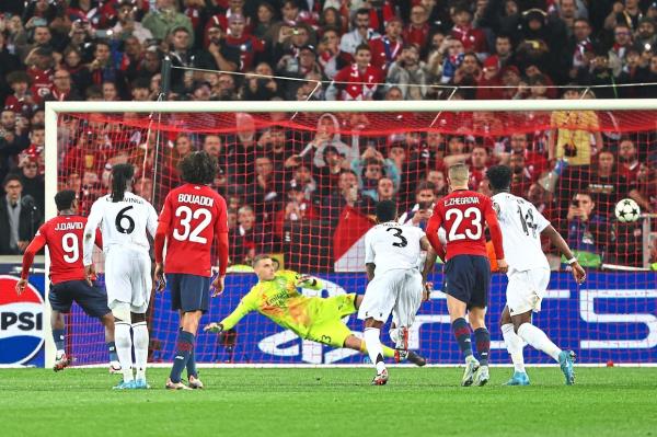 Lille’s Canadian forward Jo<em></em>nathan David (left) scores from the penalty spot past Real goalkeeper Andriy Lunin. — AFP