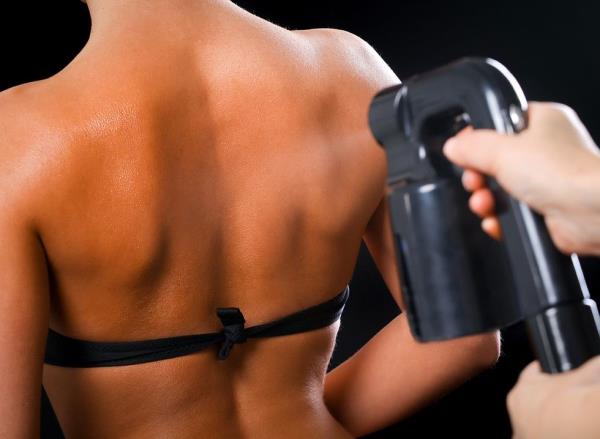 A woman in a bikini getting a professio<em></em>nal spray tan