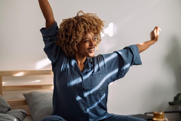 Woman waking up and looking happy.