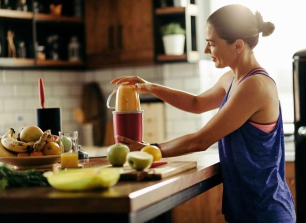 woman making fruit smoothie, co<em></em>ncept of habits that blast belly fat